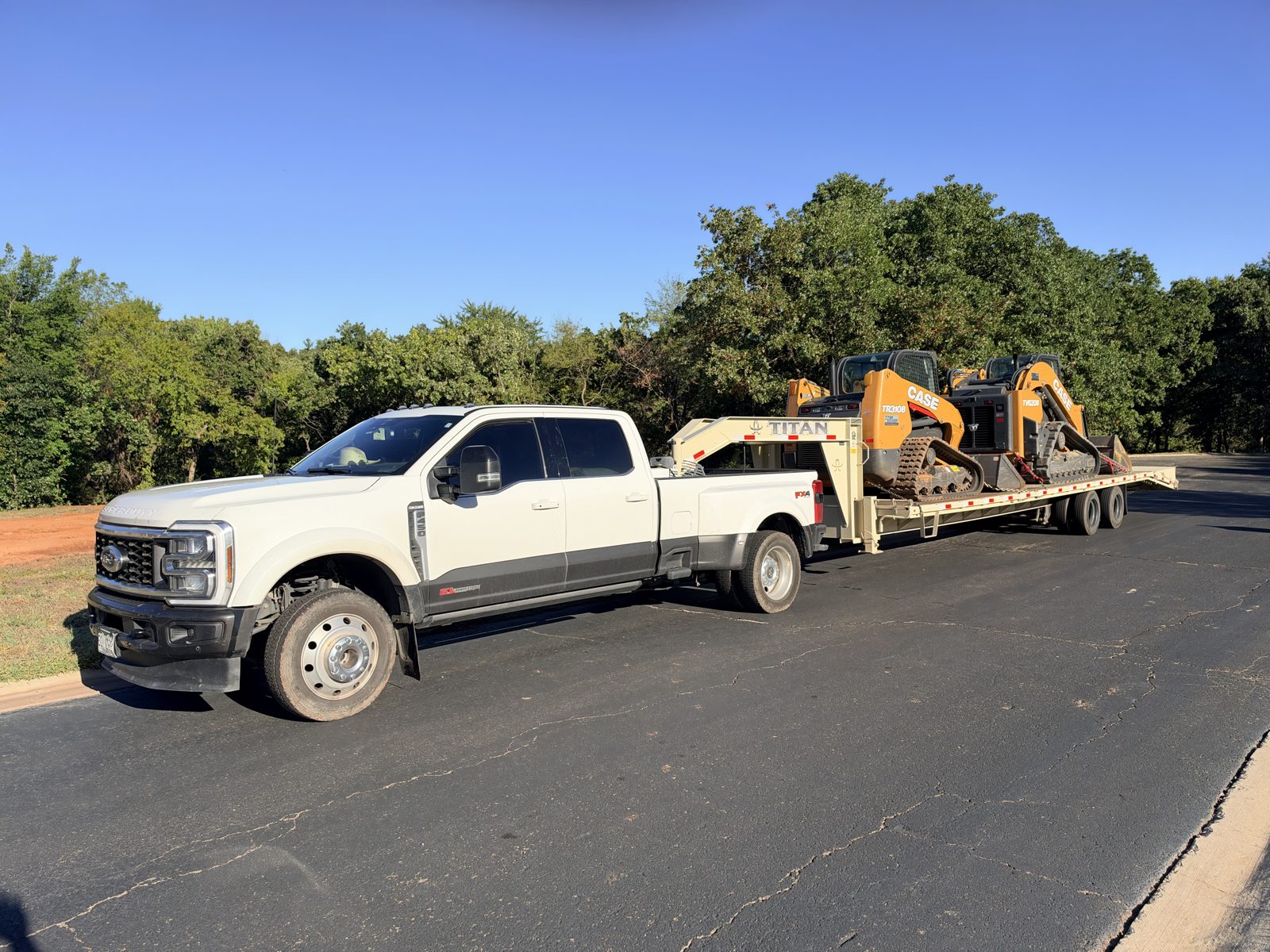 Two Case track loaders on a gooseneck trailer headed to a job