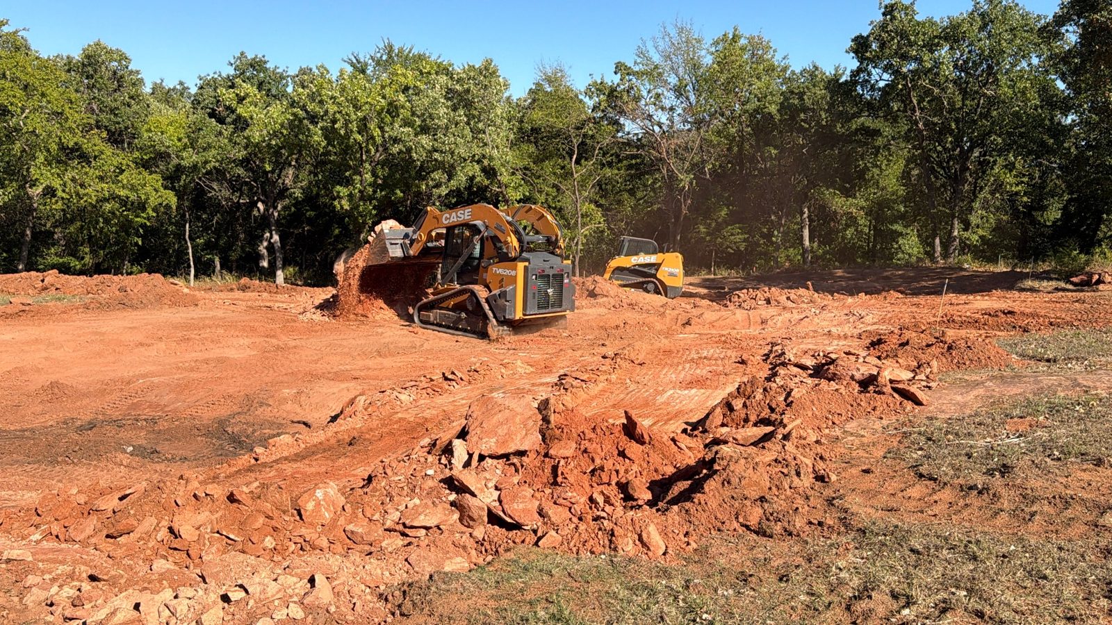 Track loader pushing rock and dirt during lot preparation