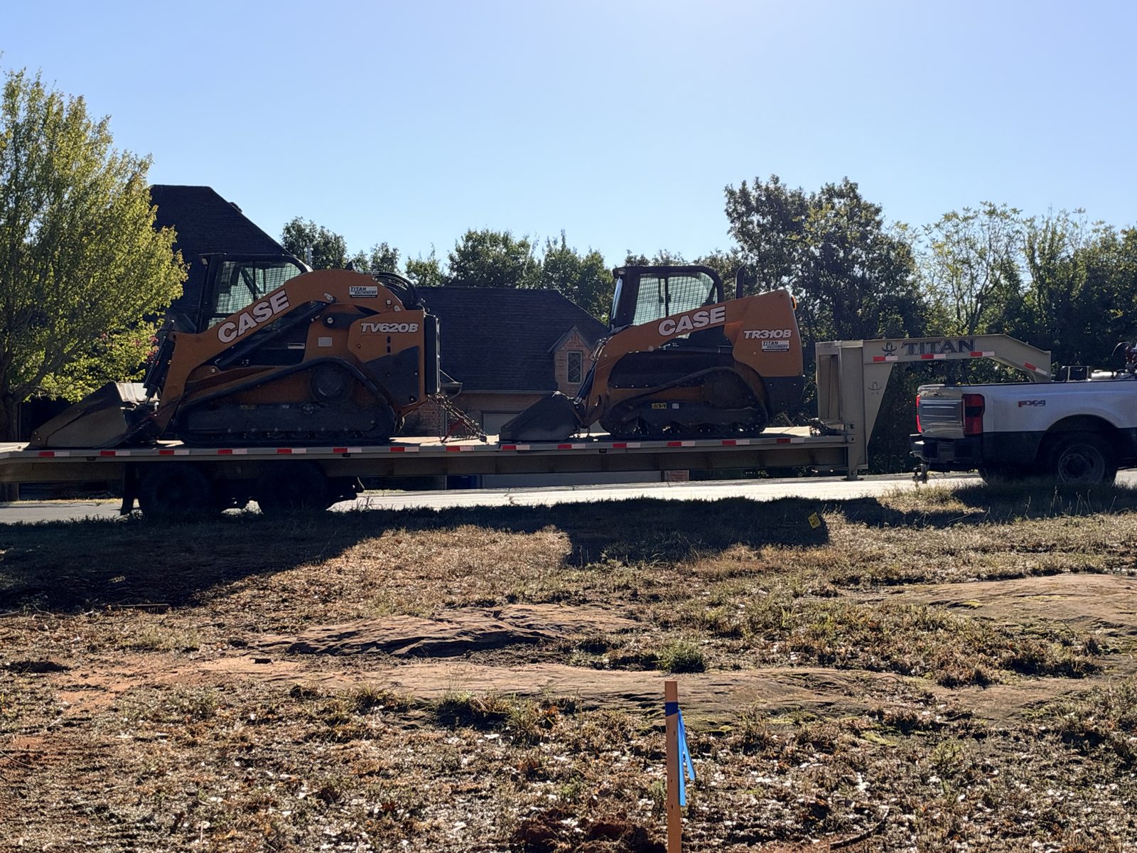 Equipment trailer arriving at a residential lot ready for site prep